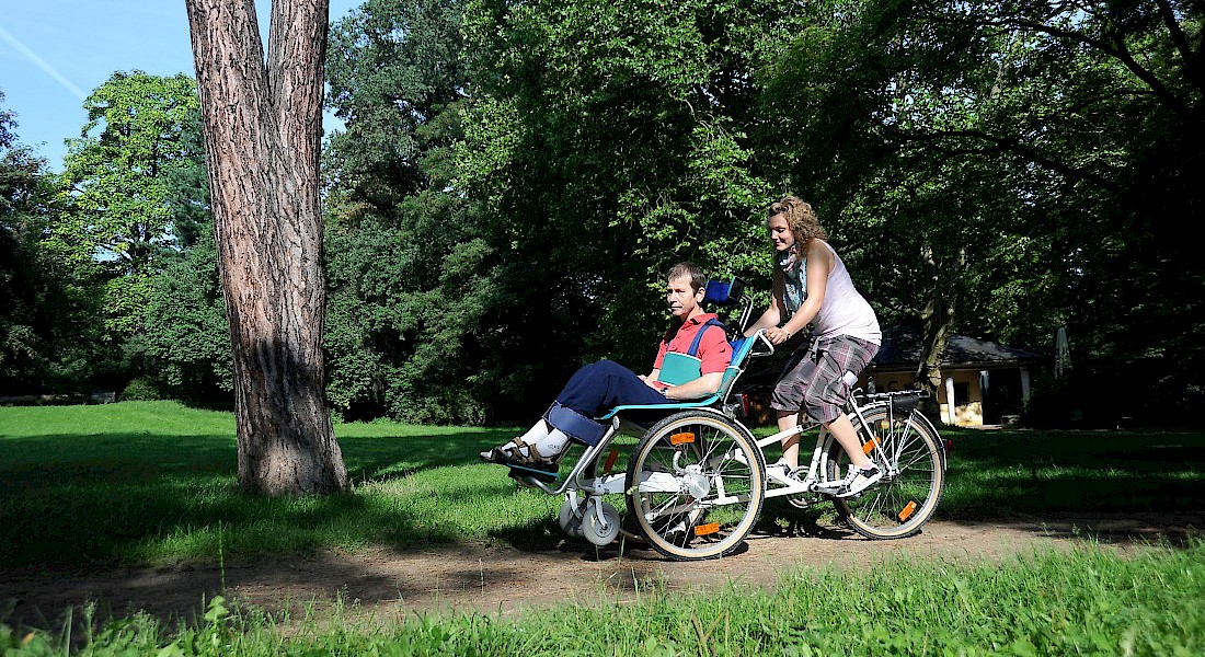 Zwei Persronen radeln durch den Park.