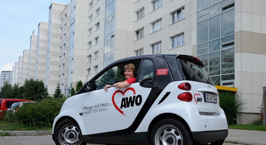 AWO-Auto vor einer Reihe von Wohnblocken.
